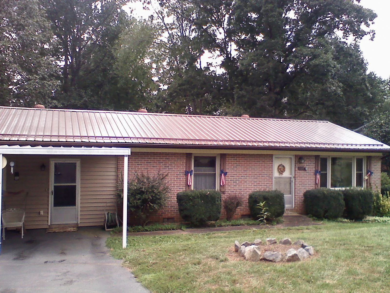 Bronze metal roof and carport on a brick ranch home — Roof Repair work by our crew in Nortonville